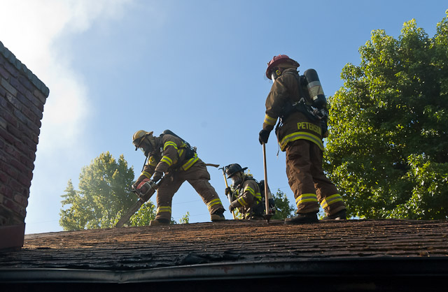 Ross Valley Firefighters ventilate a roof at an early morning structure fire in Sleepy Hollow.  Photo by Todd Lando.